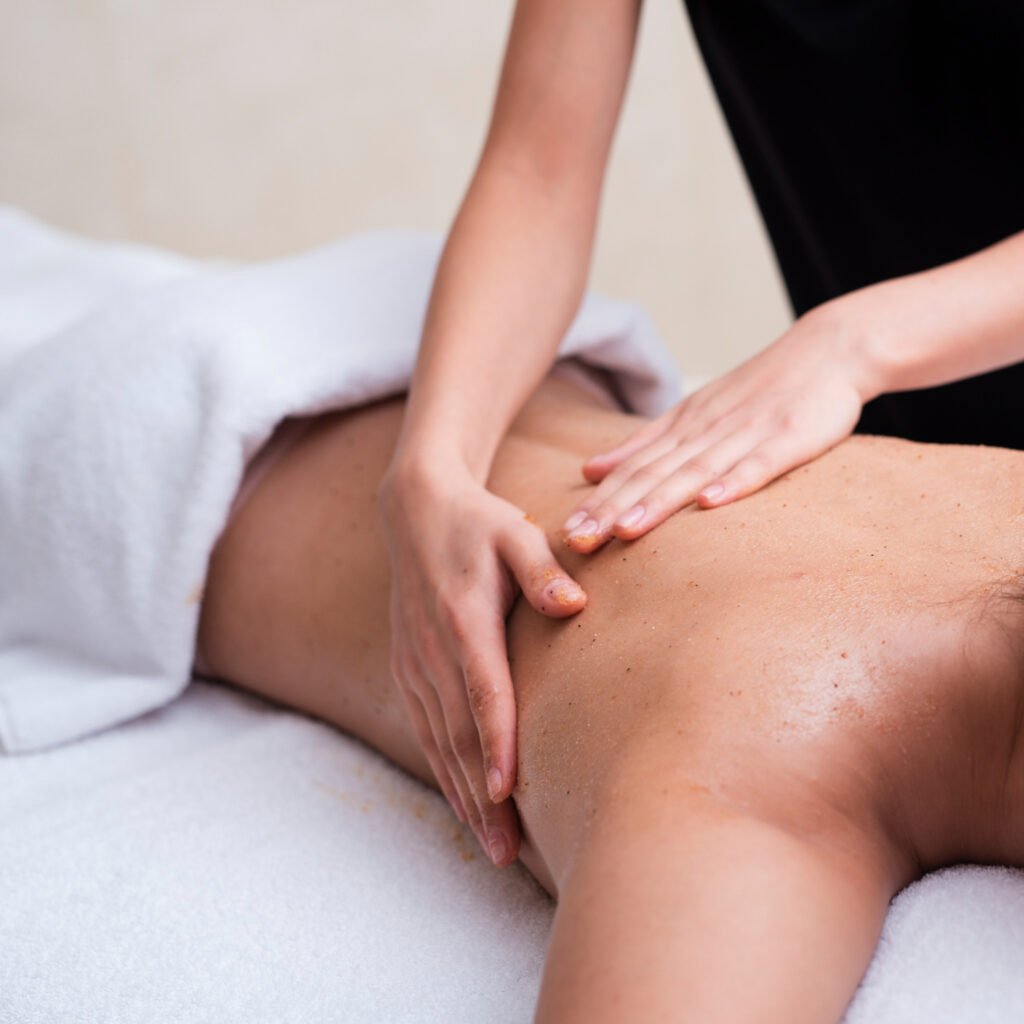 Therapist’s hands massaging a client’s back